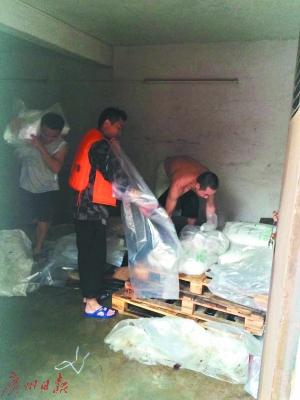 ▲消防官兵正在制衣厂紧急搬运危化品。