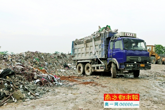 在垃圾堆放点，一辆准备倾倒垃圾的泥头车见环保工作人员到场，停止倾倒准备离去。南都记者 黎湛均 摄