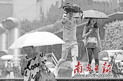 16日，在深圳市深南路上，突然而来的降雨给市民出行带来不便。南方日报记者 朱洪波 摄