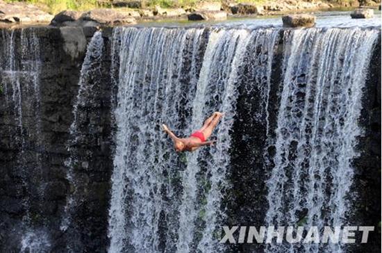 “瀑布跳水第一人”狄焕然在镜泊湖景区吊水楼瀑布进行表演。（新华社记者 李勇摄）
