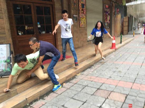 宋先生(绿衣者)与疑似女酒托分手,争执抢夺一部手机,另有4男1女却突然出现助阵女方。南都记者 祝勇摄