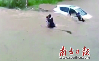 志愿者从洪水中将女车主拉出车外（志愿者手机拍摄）。