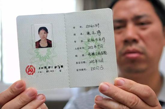 父亲拿着熊玉婷的学生证。南都记者 赵炎雄 摄