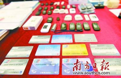　　广东警方展示缴获的电信诈骗涉案银行卡、电子密码器等。南方日报记者 肖雄 摄