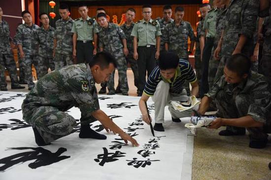 著名军旅书画家朱墨国庆节期间与南疆装甲兵某部战友一起创作巨幅书法
