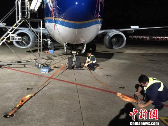 珠海机场 工作人员加固飞机和机务设备 南航供图