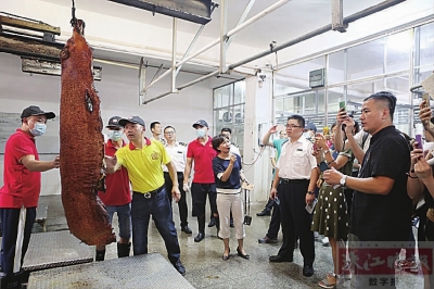 在西樵食品集中加工中心，记者们正在采访烧腊的制作过程。珠江时报记者/穆纪武摄