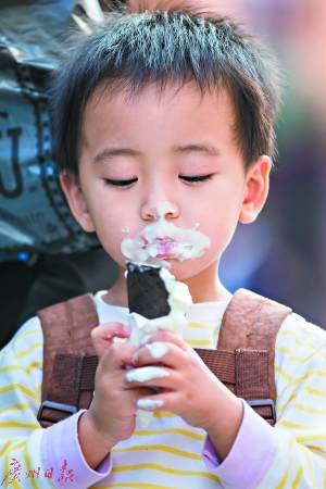 大口吃冰激凌的小朋友，十分可爱。广州日报记者陈忧子 摄