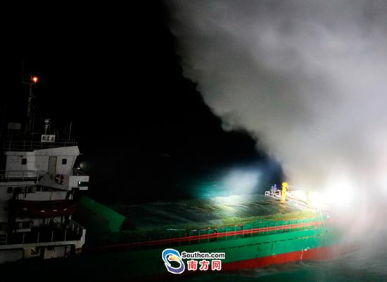 图为南海救102轮对失火货船进行消防灭火救助
