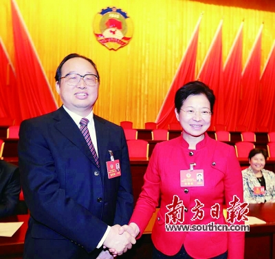 十一届市政协主席陈训廷（左）与新任市政协主席黄雁行握手。
