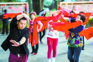 在人民公园，舞蹈老师彭加骏正领着一群中老年女舞者跳舞。