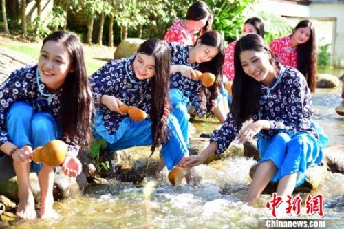 资料图:姑娘在湖边洗发。 曾令华 摄
