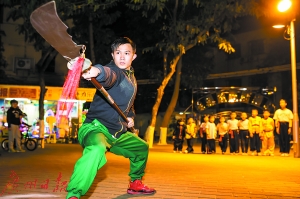 放学后，阿燊在位于广园路的蔡李佛武馆外，给少儿武术训练班的孩子们演示舞关刀。