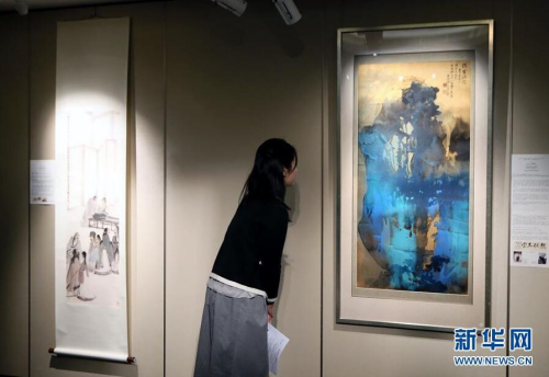 3月14日,一位记者在香港苏富比春拍记者会上观看张大千的泼墨泼彩山水画作《灊霍瑞霭》。香港苏富比将于4月4日举行中国书画专场拍卖会,呈献逾300幅中国近现代书画佳作,总估值约1.6亿港币。 新华社记者 李鹏 摄