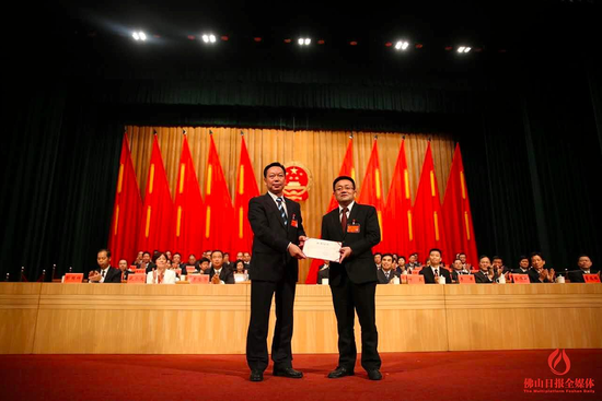 　　南海区人大常委会主任赵崇剑向南海区委副书记、南海区区长顾耀辉（右）颁发当选证书。图/佛山日报记者王伟楠摄
