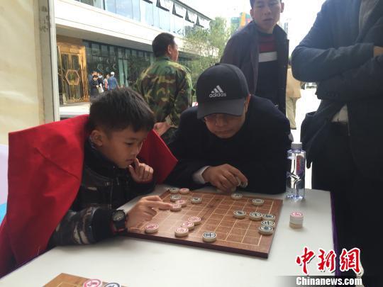 图为国际象棋大师吕钦在惠州市举办的“名人象棋对抗赛”上，观看并指导来自北京棋手操向农在与棋手刘青峰的对袂。　宋秀杰 摄