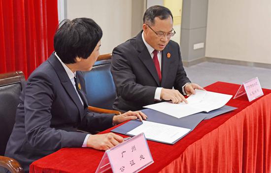 广州市公证处主任韦翠坚(左1)与广州市白云区法院院长邓淦华(左2)签署诉讼与公证对接合作协议。
