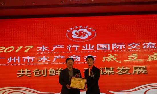 广州市民政局夏健处长（上图左）给广州市水产商会会长郑少逵颁牌