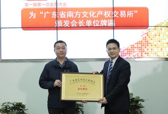 广东省文化厅副厅长刘启宇（左）为南方文交所颁发会长单位牌匾