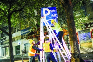 4月1日凌晨1时许,海珠区赤岗北路,工人们在咪表“收费车位”的牌子上张贴“暂停收费”的告示。