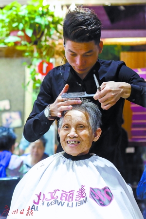 老人在理发店内接受义剪服务
