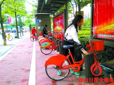 13日8时许,禅城岭南大道北东江花苑公共自行车站点内,一名市民刷卡借车。/组图由佛山日报记者陈晨摄