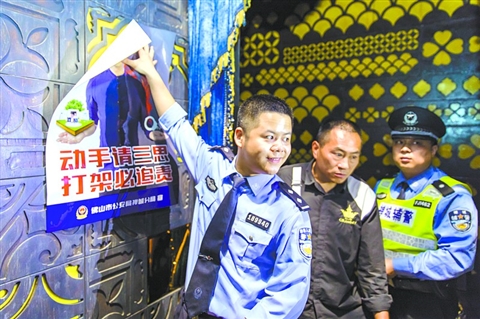 昨日,在禅城区创意产业园格莱美汇内,禅城公安民警在显著位置张贴“劝架”海报。 /佛山日报记者王澍摄