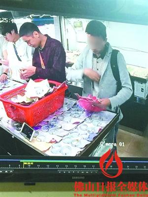 平洲玉器街，一灰衣男子在徐女士店中“看”玉镯。/视频截图