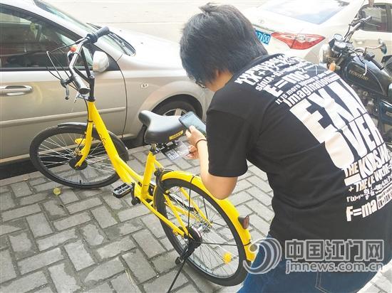 市民在扫描共享单车二维码前，应仔细观察是否出现被撬或覆盖的痕迹。江门日报记者 陈丝柳 摄