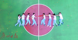 学生摆出各种造型拍毕业照。