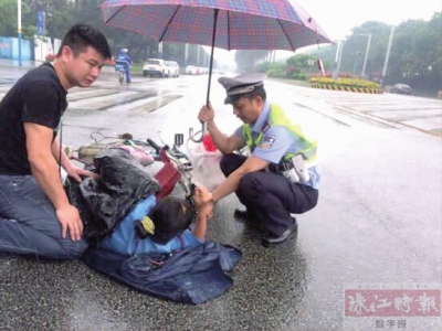 女子雨中遇车祸倒地 民警为其撑伞并护送至医院