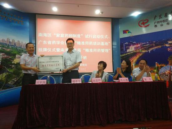 广东省药学会秘书长郑志华向南海区卫计局副局长、医院管理局局长邱宇翔授牌