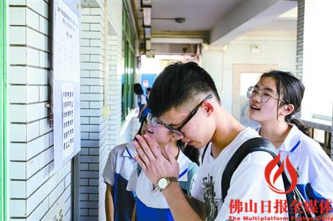昨日，佛山一中考点，一位考生在确认完自己的名字与座位号后祈祷考试顺利。/佛山日报记者王澍摄