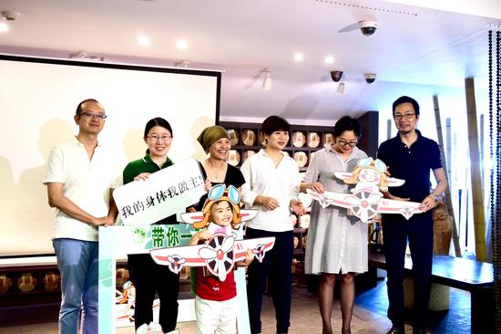 蔡文方与前来观看《“丁丁豆豆”成长故事》首映的小朋友、家长们互动合影