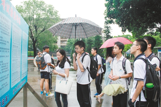 在景贤学校考点有很多老师和家长冒雨陪着孩子看考场。