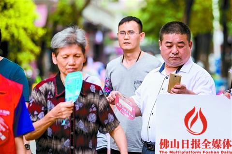 昨日下午大雨过后,天气闷热,禅城区同华东二路上的市民们正在不停地摇扇子消暑。/佛山日报记者王澍 实习生杨伟健摄