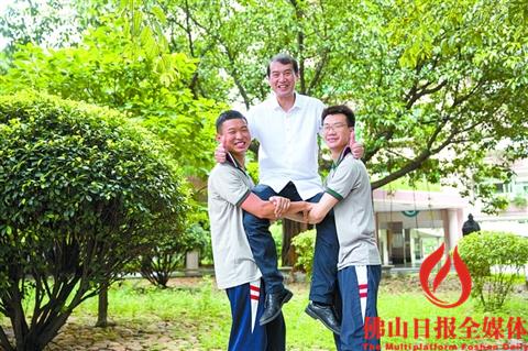 昨日,石门中学18班的学生何鸿魏(左)和陈志杰(右)将班主任黄志平高高托起。黄志平也是全省文科前十谭慧仪的班主任。何鸿魏排名全省前20,陈志杰排名全省第74名。 /佛山日报记者王伟楠摄