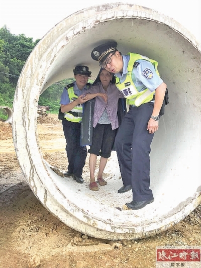 民警带老人到大型排水管预制件躲雨。(通讯员供图)