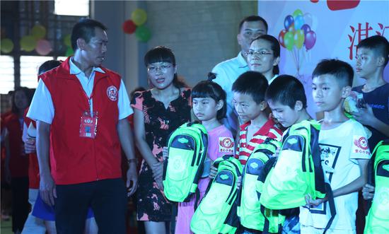 政府领导与协会会长为留守儿童发书包