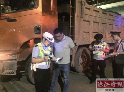 执法人员正在核查渣土运输车辆驾驶员的相关证件。