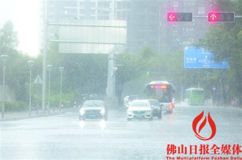 昨日，大雨突袭，禅城港口路上，汽车开着车灯等待红绿灯。/佛山日报记者王伟楠摄