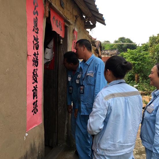 坡头区供电局官渡所志愿者们走访镇留屋村，图为志愿者活动核查线路。肖瑜 摄