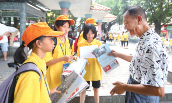 小记者们走上街头卖报纸，并且采访市民对于传统报纸的看法。/珠江商报记者周焯杰摄