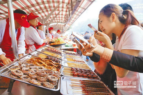 北京一“虫子宴”摊位,摆满串蛇、蜈蚣、蚂蚱、蜘蛛等,不少食客拿出手机拍照。台湾中时电子报