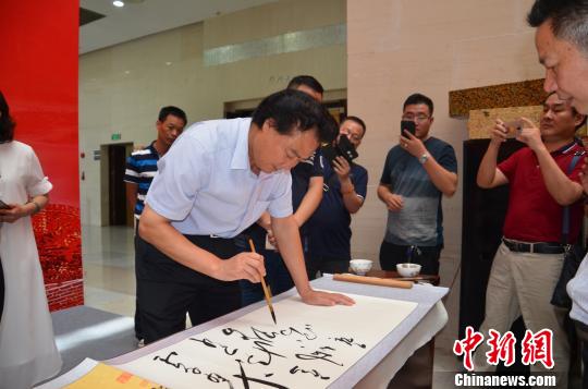 图为著名毛体书法家安想珍在为“铁军魂”书画长卷题词 宋秀杰 摄