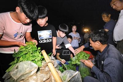 凌晨3点半,孩子们到北山市场批发蔬菜,大家忙着讨价还价。