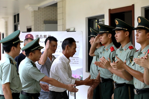 谭念烈士父亲与第六任谭念班战士握手
