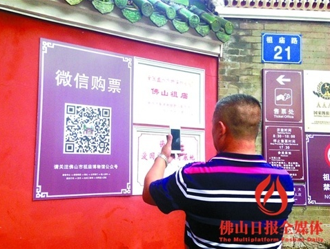 一名游客在祖庙门口,通过微信购买门票,免去排队之苦。