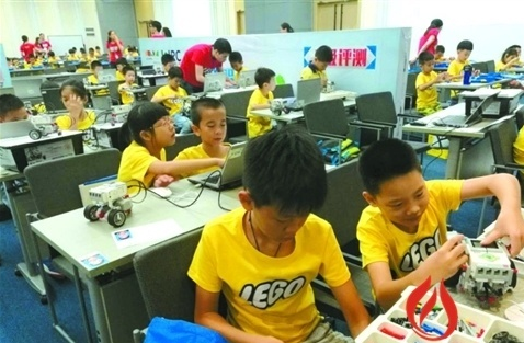 孩子们正在通过电脑编程设计程序，搭建机器人。/佛山日报记者潘宇莹摄