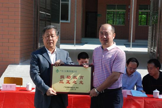 广东省教育基金会秘书长许怀升先生向广东三正集团形象管理部总经理李华先生回赠牌匾
